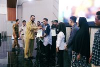 Foto Bupati Halsel Hasan Al Bassam Kasuba menyerahkan sertifikat tanah kepada warga, Senin (26/2/2024)